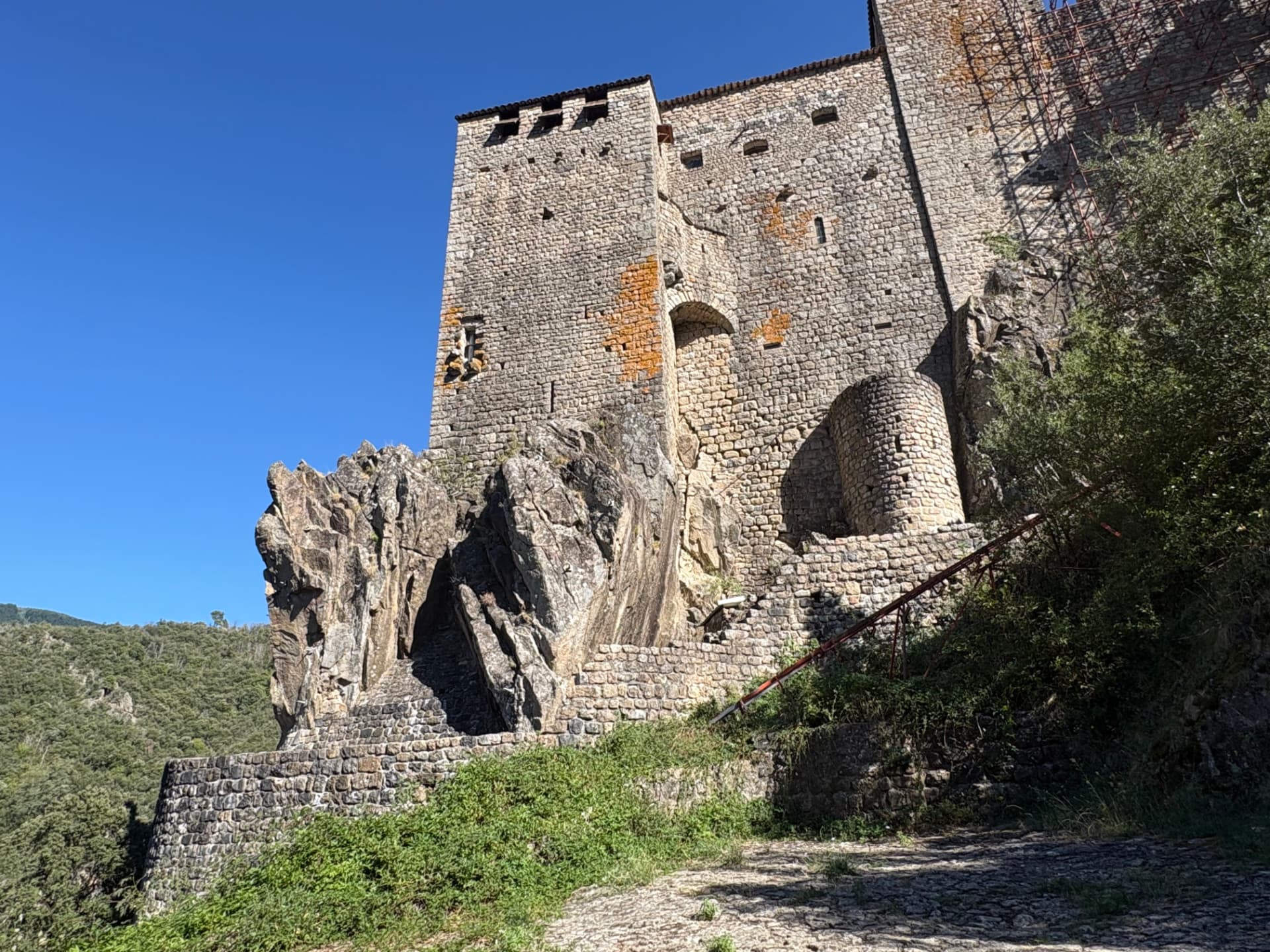 Façade du château de Ventadour construite sur le rocher, avec l'escalier de pierre qui mène à l'entrée