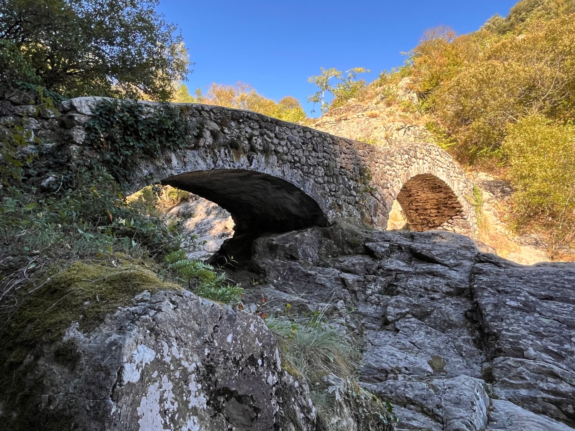 Pont ancien de Jaujac vu depuis le lit rocheux de la rivière