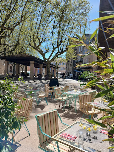 Tables et chaises de la terrasse du Taka sous les arbres de la place