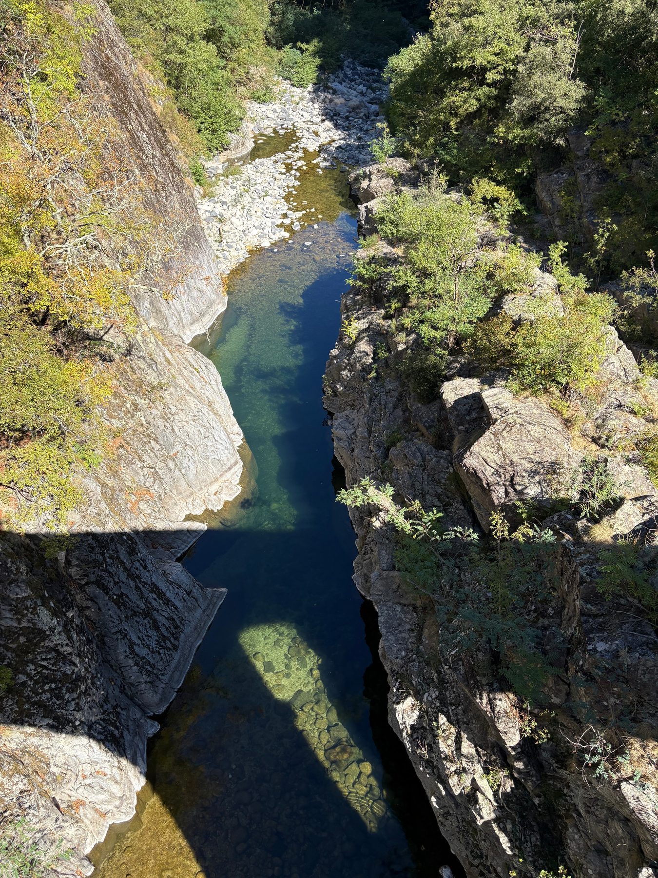 Vue plongeante sur une gorge étroite où coule une rivière limpide entre des rochers