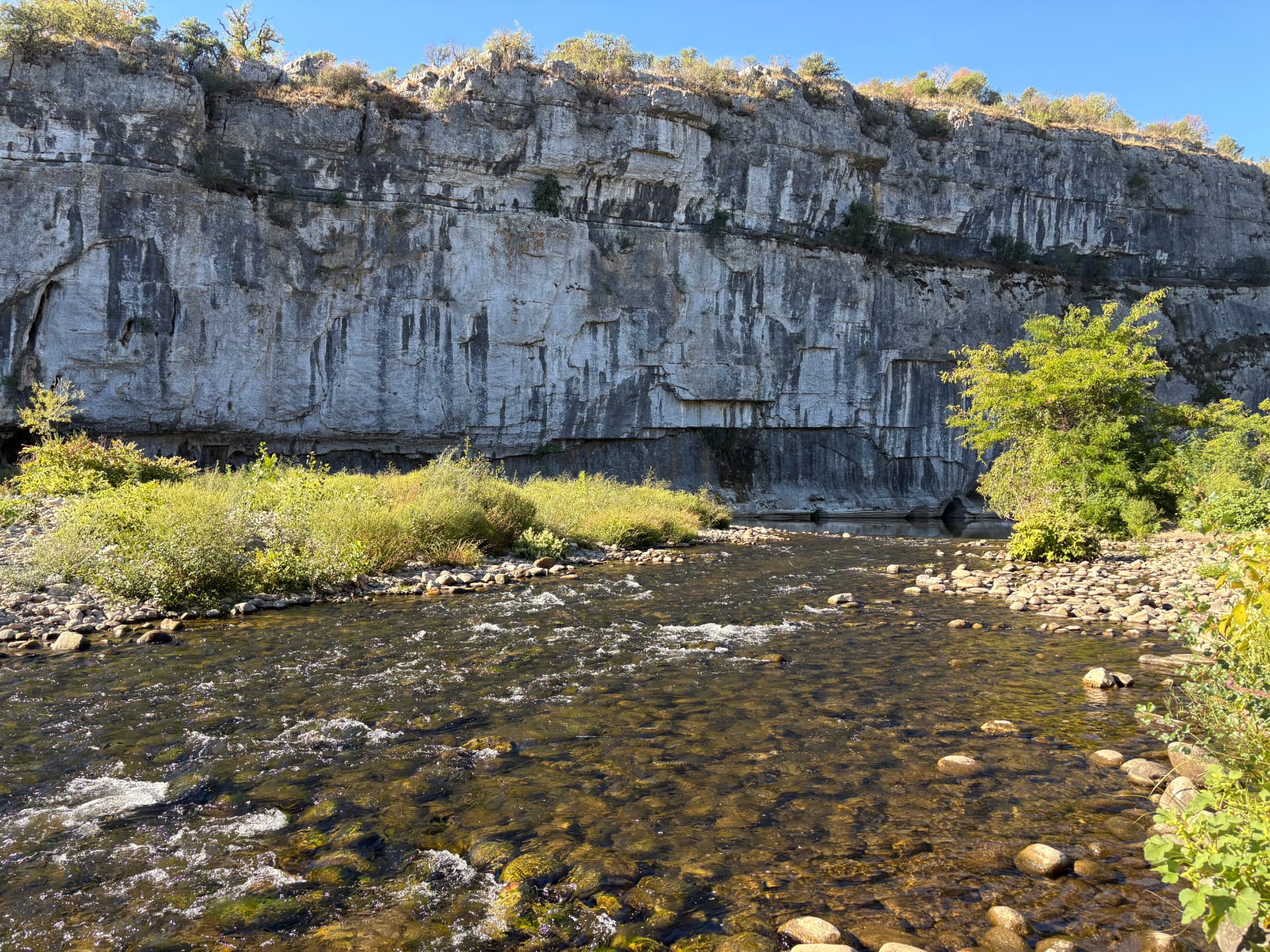 Le Chassezac coulant au pied d'une grande falaise calcaire