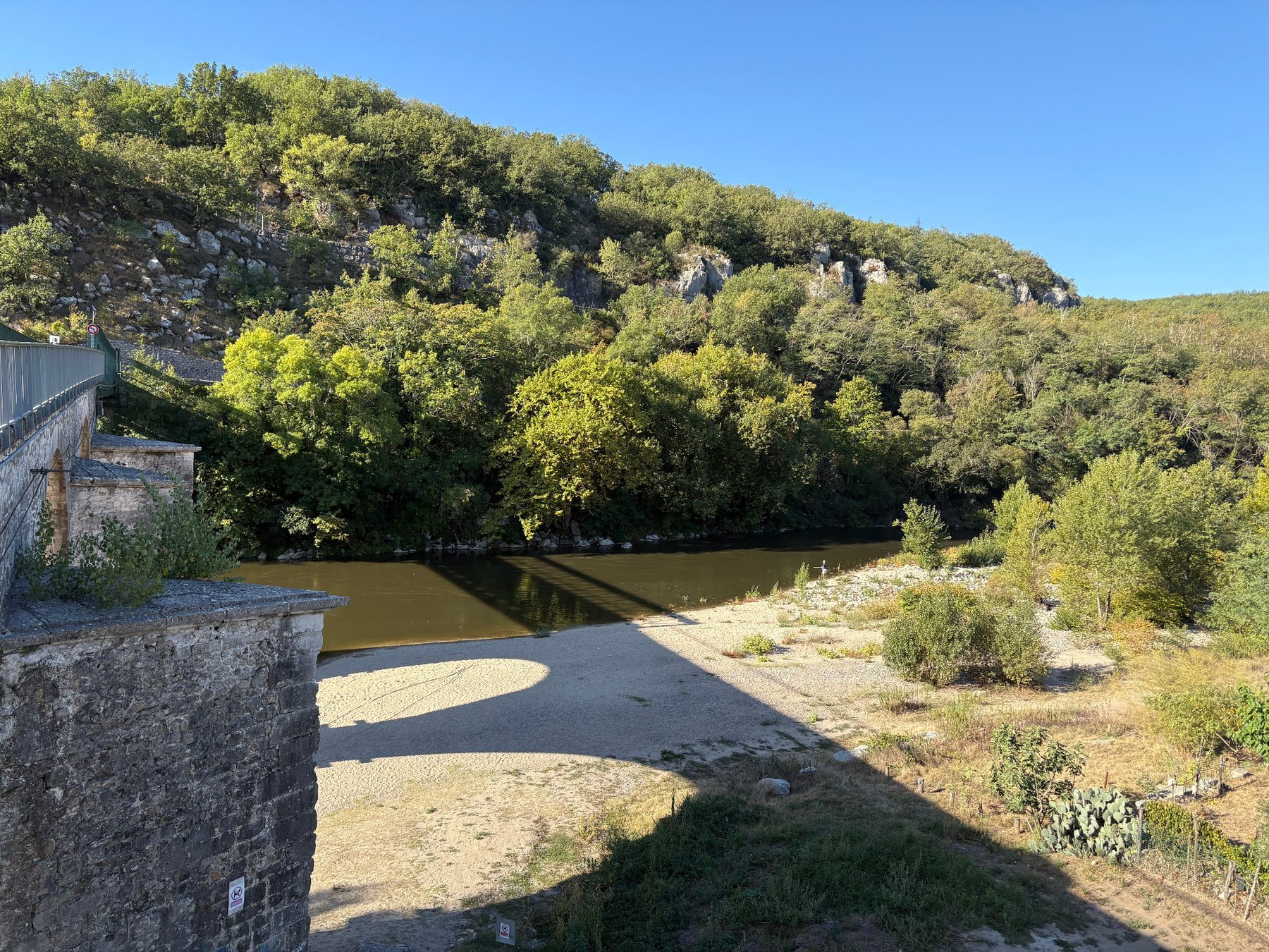 Berge de galets et plage au bord de l'Ardèche à Vogüé, vue depuis le pont