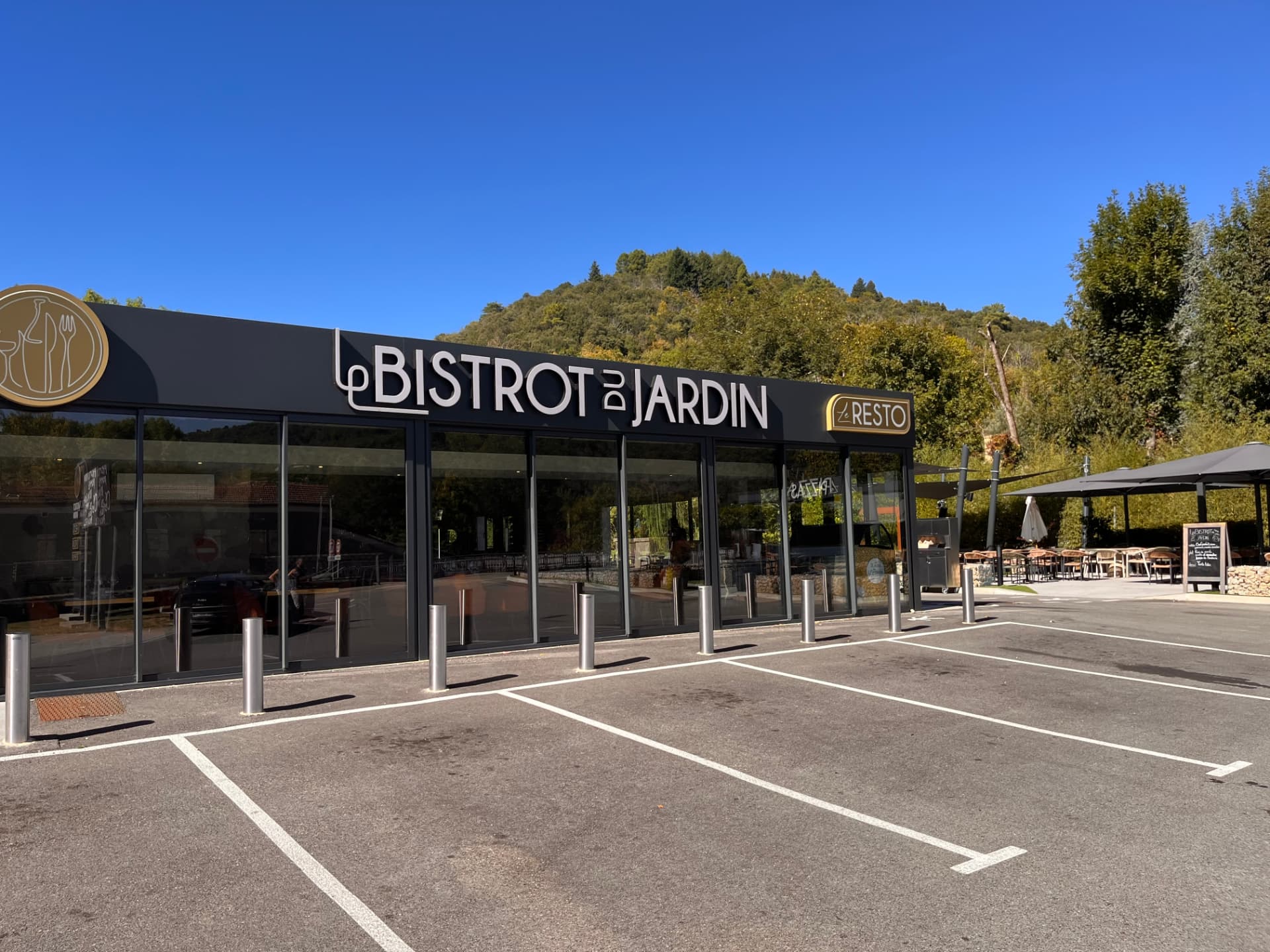 Façade vitrée du Bistrot du Jardin à Fabras, avec son enseigne « Le Bistrot du Jardin » et le panneau « Le Resto »