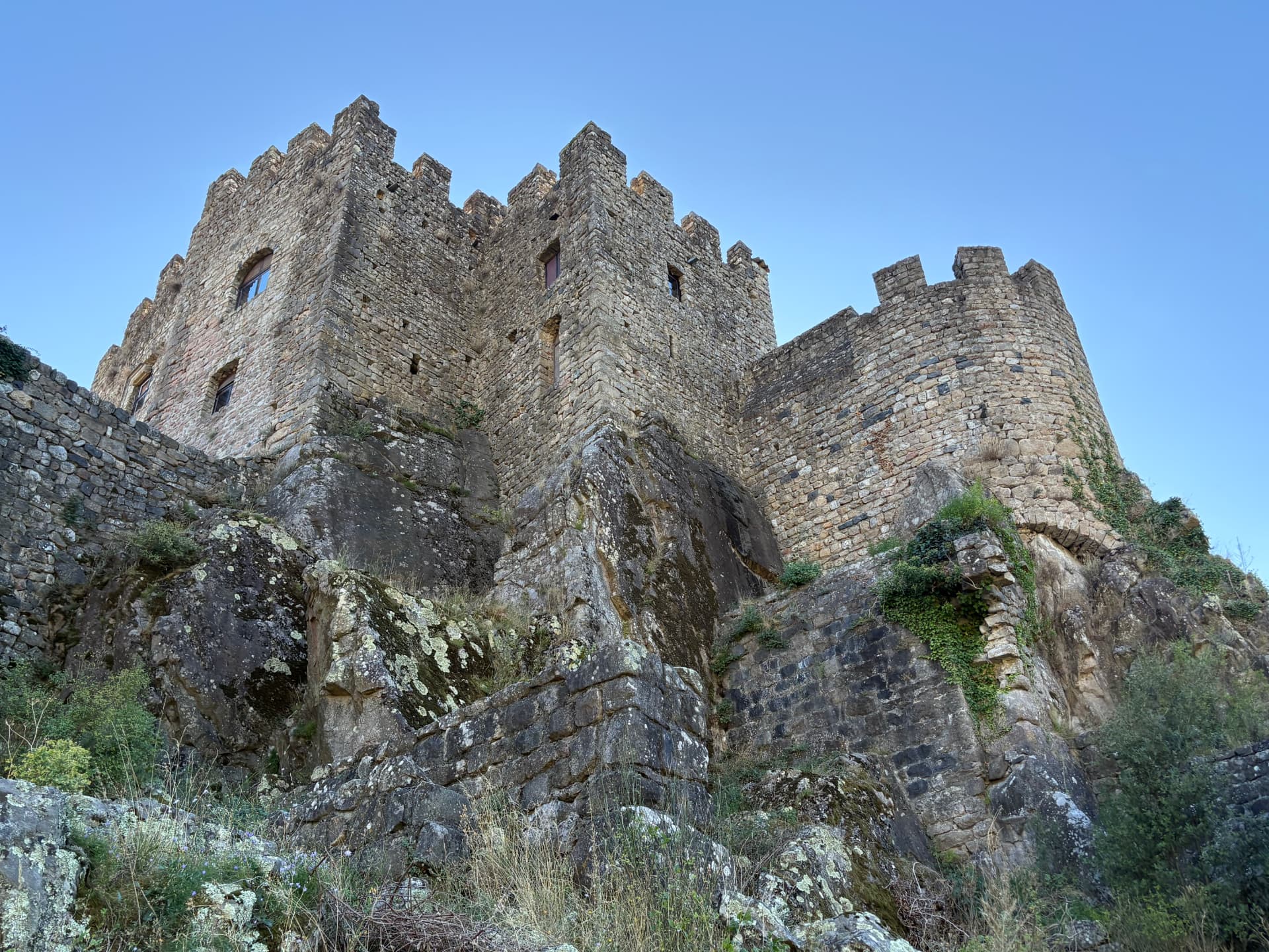 Château de Ventadour en Ardèche, tours crénelées dressées sur leur éperon rocheux sous un ciel bleu