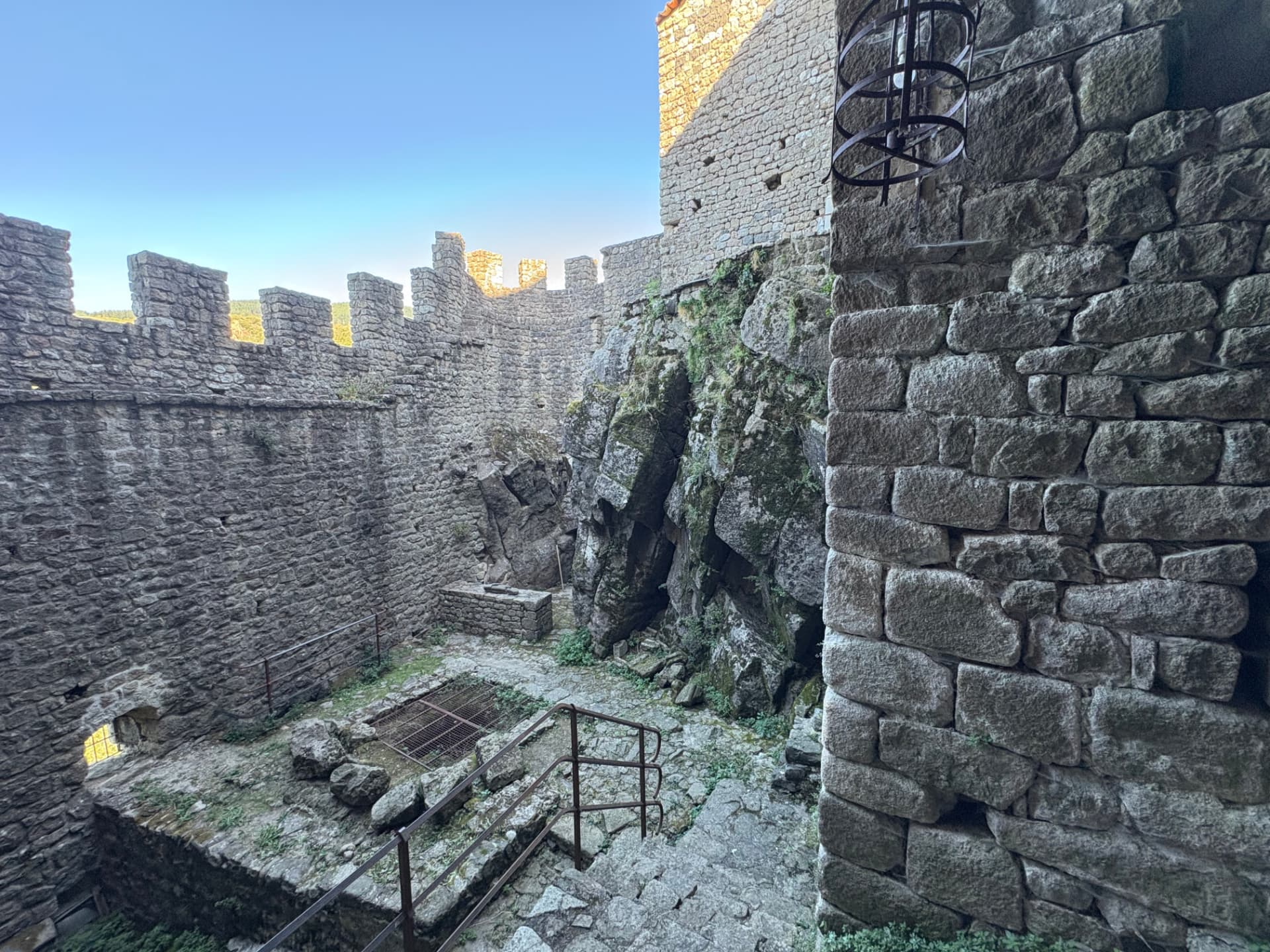 Cour intérieure du château de Ventadour, murailles crénelées et rocher affleurant